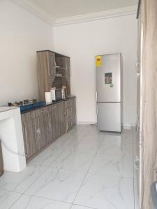 a kitchen with a refrigerator and wooden cabinets at Sigma Theta Homes - Old Tafo in Kumasi