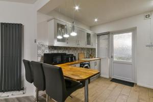 a kitchen with a wooden table and black chairs at Bromley Palace - Entire 2 Bed House - Free Parking - Self Check-in in London