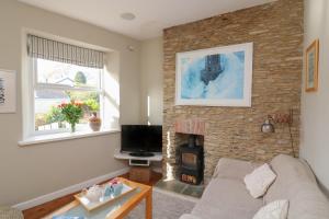 a living room with a fireplace and a couch at 1 Bailey's Cottage in Dartmouth