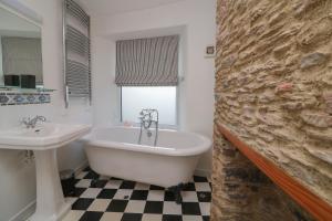 a bathroom with a bath tub and a sink at 1 Bailey's Cottage in Dartmouth +15 photos