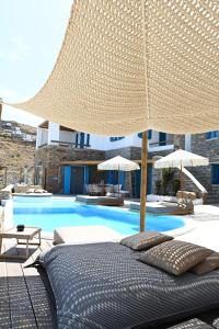 a bed with an umbrella next to a swimming pool at Keablue in Melissaki