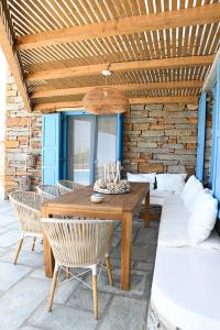 a wooden table and chairs on a patio at Keablue in Melissaki