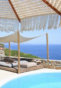 a hammock on a patio next to a swimming pool at Keablue in Melissaki