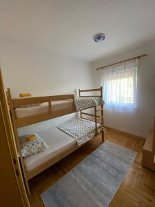 Un dormitorio con dos literas y una ventana. en Apartman DIS, en Trebinje