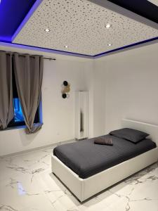 a bedroom with a bed with a blue ceiling at Appartement T3 Terrasse 