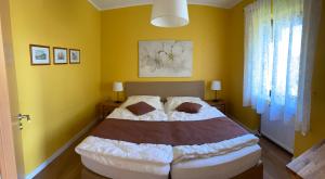 ein Schlafzimmer mit einem großen Bett mit gelben Wänden in der Unterkunft Traumhaus am Maar 1 in Schalkenmehren