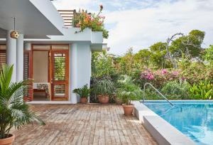 a house with a swimming pool and plants at Jakes Hotel in Treasure Beach