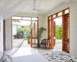 Schlafzimmer mit einem Bett und Glasschiebetüren in der Unterkunft Jakes Hotel in Treasure Beach