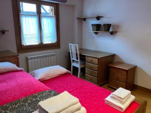 Un dormitorio con dos camas y un escritorio y una silla. en Urumea Apartamento, en Goizueta