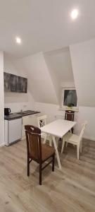 cocina con mesa blanca y sillas en una habitación en Tim's Guesthouse en Hannover