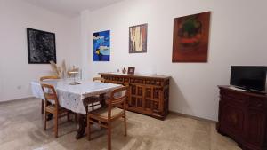 una sala da pranzo con tavolo, sedie e TV di Savena House a Bologna