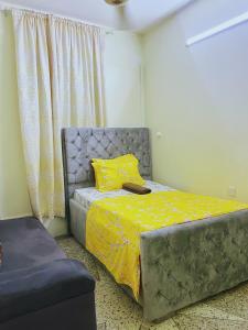 a bedroom with a bed with a yellow comforter at Rafiki Guest House in Ngambo