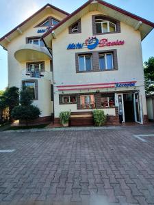 a hotel building with a sign that reads metro beauty at Motel Davios in Târgu Jiu