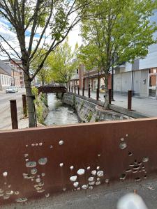 a metal fence with a river in a city at City apartment Dæmningen Vejle in Vejle