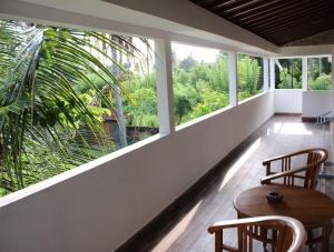 a room with two chairs and a table and windows at Villa Kayu Padangbai in Padangbai