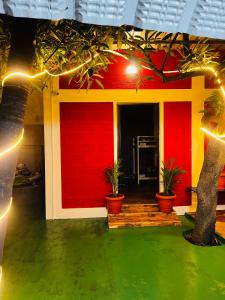 a house with a red wall and potted plants at Hostel kuruku santhu colive in Puducherry
