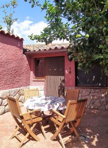 una mesa y dos sillas sentadas frente a una casa en Jinoba25, en Castillo de Bayuela