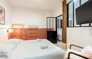 a bedroom with a white bed and a tv at NEW Gorgeous Flat-Central Area in Paris