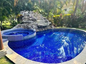 una gran piscina con cascada en un patio en alquiler puerto de San Jose, en Puerto San José