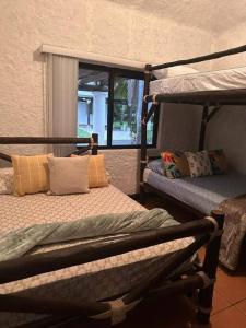 Pokój z 2 łóżkami piętrowymi i oknem w obiekcie alquiler puerto de San Jose w mieście Puerto San José