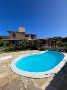 uma grande piscina azul em frente a uma casa em Casa Girassol em Pipa