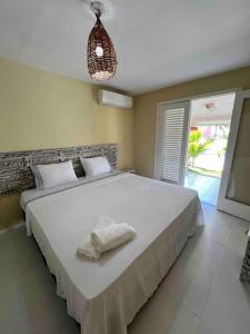 um quarto com uma cama grande com duas toalhas em Casa Girassol em Pipa