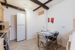 a small kitchen with a table and a refrigerator at Stratford Great Rooms to stay - 20 in London