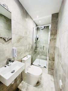 a bathroom with a toilet and a sink and a shower at Studio 12 in London