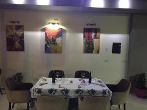 a dining room with a table with chairs and paintings at Hotel Zogu in Bulqizë