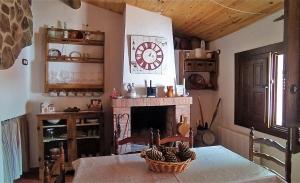a living room with a fireplace and a clock on the wall at Jinoba25 in Castillo de Bayuela