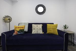 - un canapé bleu avec des oreillers dans le salon dans l'établissement Adelles seaside retreat, à Hove