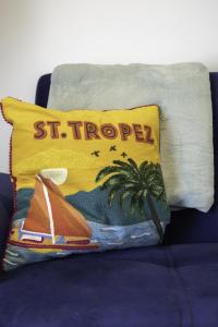 a yellow pillow with a palm tree and a towel at Adelles seaside retreat in Hove
