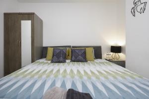 a bedroom with a bed with blue and yellow stripes at Adelles seaside retreat in Hove