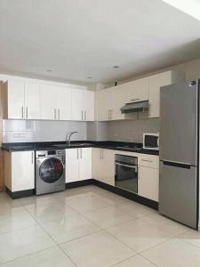 a kitchen with white cabinets and a washer and dryer at Holikeys - Agadir - 2 Ch - Aourir 005 in Agadir