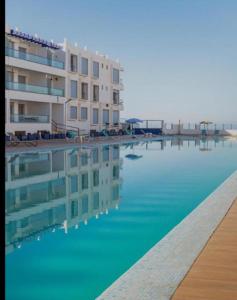a large pool of water with a building in the background at Holikeys - Agadir - 2 Ch - Aourir 005 in Agadir