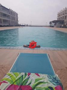 a person in a life vest laying next to a swimming pool at Holikeys - Agadir - 2 Ch - Aourir 005 in Agadir