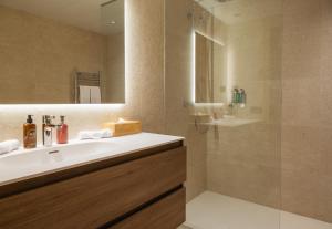 een badkamer met een wastafel en een douche bij ISARD RESIDENCES & SPA by Elegant Residences in El Tarter