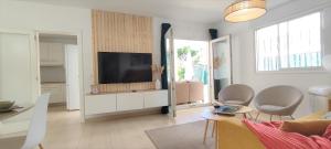 a living room with a flat screen tv on a cabinet at Bungalow Céntrico & Tranquilo in San Bartolomé de Tirajana