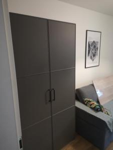 a large gray cabinet in a bedroom with a bed at apartament Stary Piec Jedlina Zdrój in Jedlina-Zdrój