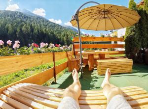 a person laying on a bench under an umbrella at Doug's Mountain Getaway - 'Exclusive Mega Chalet' in Fulpmes
