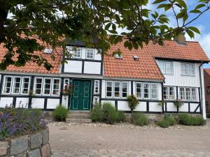 a white and black house with a green door at Ferienhaus Seemöwe in Damp