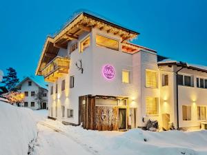 una casa nella neve con un cartello sopra di Doug's Mountain Getaway - 'Exclusive Mega Chalet' a Fulpmes