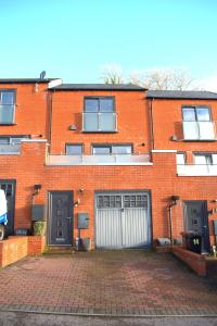 a brick building with two garage doors and a driveway at Balcony views + Parking in Lincolnshire