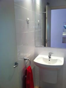 uma casa de banho branca com um lavatório e um espelho em Studio by Sants Market em Barcelona