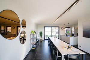 a kitchen and dining room with a long table and a mirror at Vakantiewoning Amico in Gistel