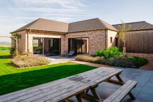 - une table de pique-nique en bois devant une maison dans l'établissement Vakantiewoning Amico, à Gistel