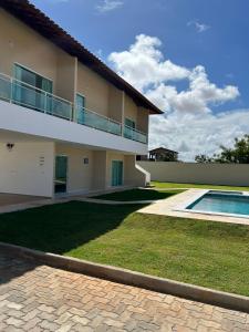 a house with a swimming pool and a yard at Meu Chale Flecheiras in Flecheiras