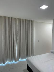 フレシェイラスにあるMeu Chale Flecheirasのベッドルーム1室(ベッド1台付)、青い照明付きの窓が備わります。