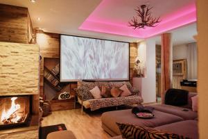 a living room with a large screen in the ceiling at Das Mountain Getaway - Exclusive Mega Chalet Stubai Super Card in Fulpmes