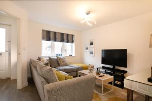 a living room with a couch and a tv at Jasmine House in Nottingham